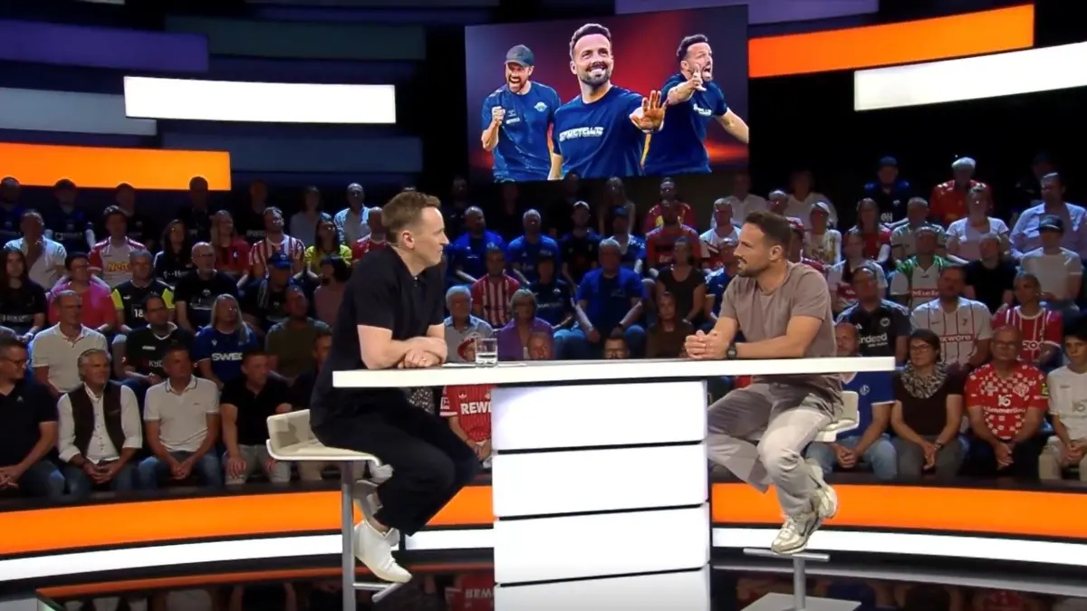Sportstudio-Moderator Jochen Breyer (links) im Gespräch mit Ralf Kettemann. Rechts neben Breyers Arm sind Ulrich und Barbara Kettemann zu sehen, die Eltern des Paderborner Trainers.