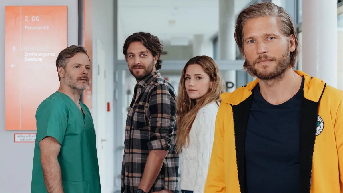 Nach den positiven Nachrichten von Dr. Nick Aichstetter (Nicholas Reinke, l.) steht der Hochzeit von Sofia Conti (Mitsou Jung, 2.v.r.) und Stefan Bergstätter (Frederik Götz, 2.v.l.) nichts mehr im Weg. Und Markus Kofler (Sebastian Ströbel, r.) kommt dabei eine besondere Ehre zuteil.
