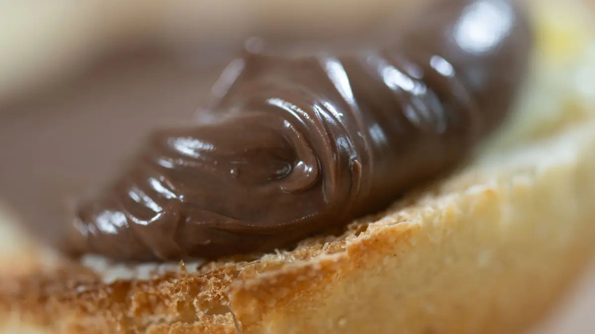 Nuss-Nougat-Creme auf einem Brötchen: ARCHIV - Die Stiftung Warentest hat 18 Nuss-Nougat-Cremes geprüft. (zu dpa: «Nuss-Nougat-Creme: Edelaufstrich und Discountermarke vorn») Foto: Hendrik Schmidt/dpa/dpa-mag - Honorarfrei nur für Bezieher des Dienstes dpa-Magazin +++ dpa-Magazin +++