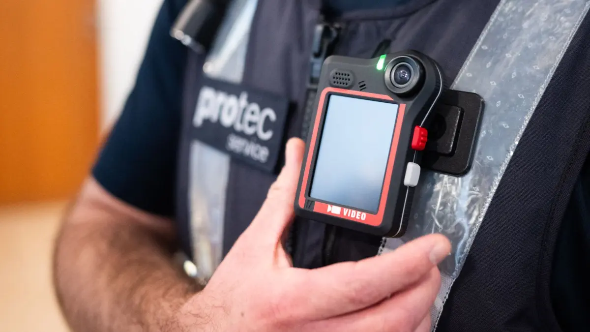 Bodycam-Pilotprojekt Stadtbahn Hannover: 03.09.2026, Niedersachsen, Hannover: Ein Mitarbeiter von protec zeigt eine neue Bodycam. Der Sicherheitsdienstleiter protec, eine Tochter der hannoverschen Verkehrsbetriebe Üstra, erprobt in einem Pilotprojekt Bodycams. Mitarbeiter werden mit Kameras ausgestattet, um bei Bedarf bestimmte Situationen in Bahnhaltestellen und in Stadtbahnen per Videoaufnahme festzuhalten. Foto: Julian Stratenschulte/dpa +++ dpa-Bildfunk +++