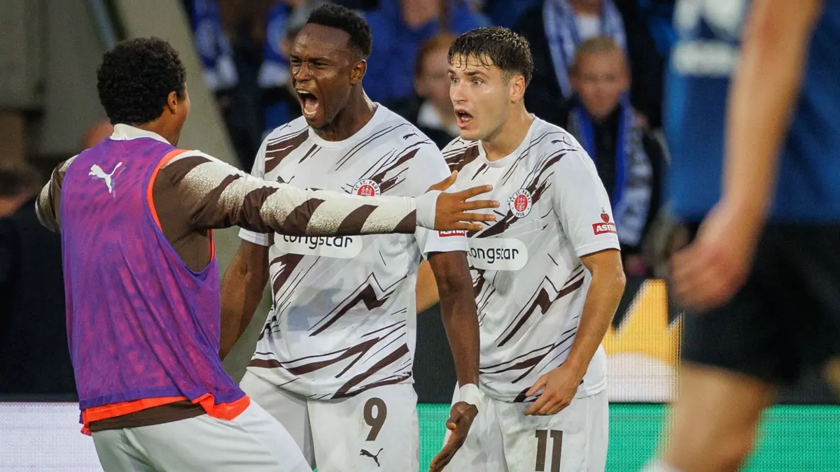 Arminia Bielefeld - FC St. Pauli: 04.09.2026, Nordrhein-Westfalen, Bielefeld: Fußball, Männer: 2. Bundesliga, Arminia Bielefeld - FC St. Pauli, 4. Spieltag, Schüco Arena. Torschütze Abdoulie Ceesay (FC St. Pauli, M.) feiert seinen Treffer zum 2:2 mit Marcus Mathisen (FC St. Pauli, l) und Arkadiusz Pyrka (FC St. Pauli, r). Foto: Friso Gentsch/dpa - WICHTIGER HINWEIS: Gemäß den Vorgaben der Bundesliga bzw. des DFB Deutscher Fußball-Bund ist es untersagt, in dem Stadion und/oder vom Spiel angefertigte Fotoaufnahmen in Form von Sequenzbildern und/oder videoähnlichen Fotostrecken zu verwerten bzw. verwerten zu lassen. +++ dpa-Bildfunk +++