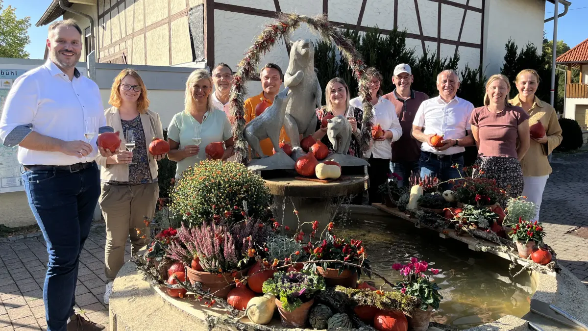 Vor dem herbstlich geschmückten Bärenbrunnen stimmen sich die Organisatoren auf den Sonnenbühler Genussweg ein. In diesem Jahr führt der Pop-Up-Wanderweg auch tief in die Geschichte Erpfingens.