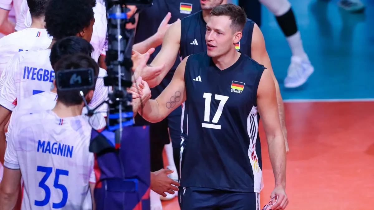VOLLEYBALL-EUR-2026-MEN-FRA-GER: Germany's Jan Zimmermann (R) greets France's players at the net during the Men's EuroVolley 2026 match between France and Germany at the BT Arena in Cluj-Napoca, Romania, on September 15, 2026. (Photo by Simion Sebastian Tataru / AFP)