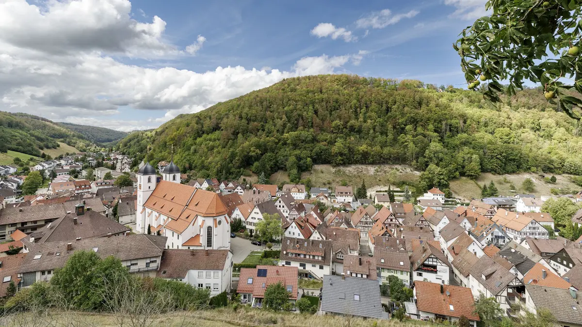 Blick, von einem leicht erhöhtem Standpunkt, auf die Ort Wiesensteig im Oberen Filstal. In der Bildmitte die katholische Stiftskirche St. Cyriakus, rechts geht der Blick Richtung Mühlhausen im Täle und links in Richtung Filsursprung.