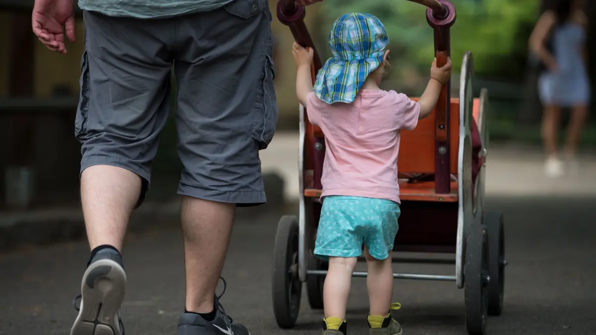 Elterngeld in Sachsen: ARCHIV - 20.06.2018, Sachsen, Dresden: Ein Mann geht mit seinem Sohn im Dresdner Zoo spazieren. (zu dpa: «SPD-Frauen fordern Familienstartzeit») Foto: Monika Skolimowska/dpa-Zentralbild/dpa +++ dpa-Bildfunk +++