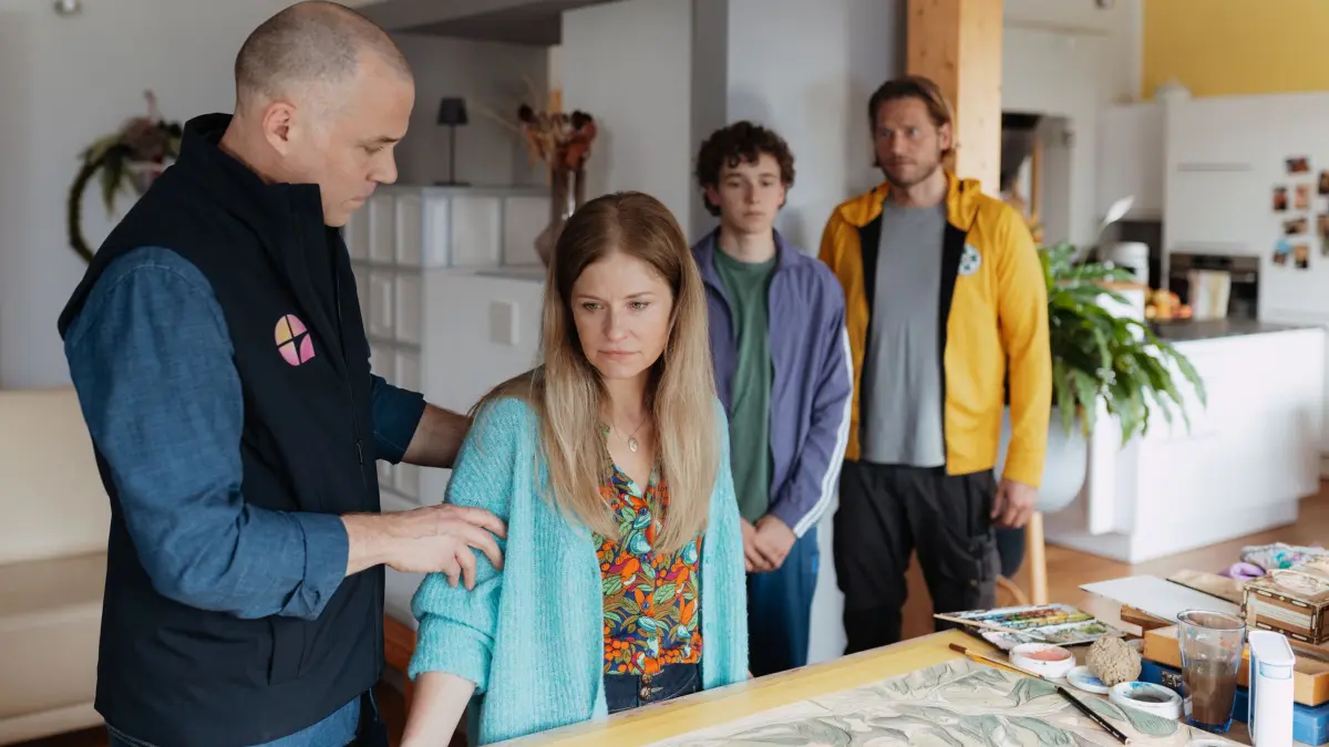 Markus (Sebastian Ströbel, r.) spielt Isabel (Birte Hanusrichter) und ihrem Sohn Elias (Leo Alonso-Kallscheuer, 2. v. r.) die Nachricht vor. Hannes Kienbacher (Bernhard Piesk, l.) ahnt, was dies bei der Familie auslösen wird.