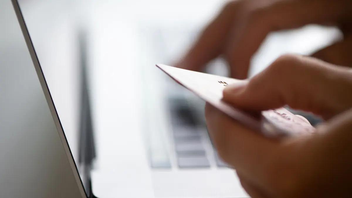 Mann sitzt mit Kreditkarte vor einem Laptop: ILLUSTRATION - Links oder QR-Codes zur vermeintlichen Zahlungsbestätigung oder angeblich fehlgeschlagene Zahlungen? Fallen Sie darauf im Kleinanzeigen-Kontext nicht herein. Hier geht es Betrügern nur darum, Ihnen Sensibles wie Kreditkartendaten abzujagen. (zu dpa: «5 Tipps gegen Betrug: So wird aus Kleinanzeigen kein Fiasko») Foto: Franziska Gabbert/dpa-tmn - Honorarfrei nur für Bezieher des dpa-Themendienstes +++ dpa-Themendienst +++