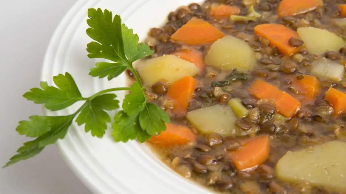 Ein Teller mit Linsensuppe: ILLUSTRATION - Klassiker auf dem Teller: Für Linsensuppe Linsen waschen, gern 8 bis 12 Stunden einweichen – dann sind sie beim Kochen oft nach 20 bis 30 Minuten weich. (zu dpa: «Tellerlinsen: Vor dem Kochen salzen oder erst am Ende?») Foto: Andrea Warnecke/dpa-mag - Honorarfrei nur für Bezieher des Dienstes dpa-Magazin +++ dpa-Magazin +++