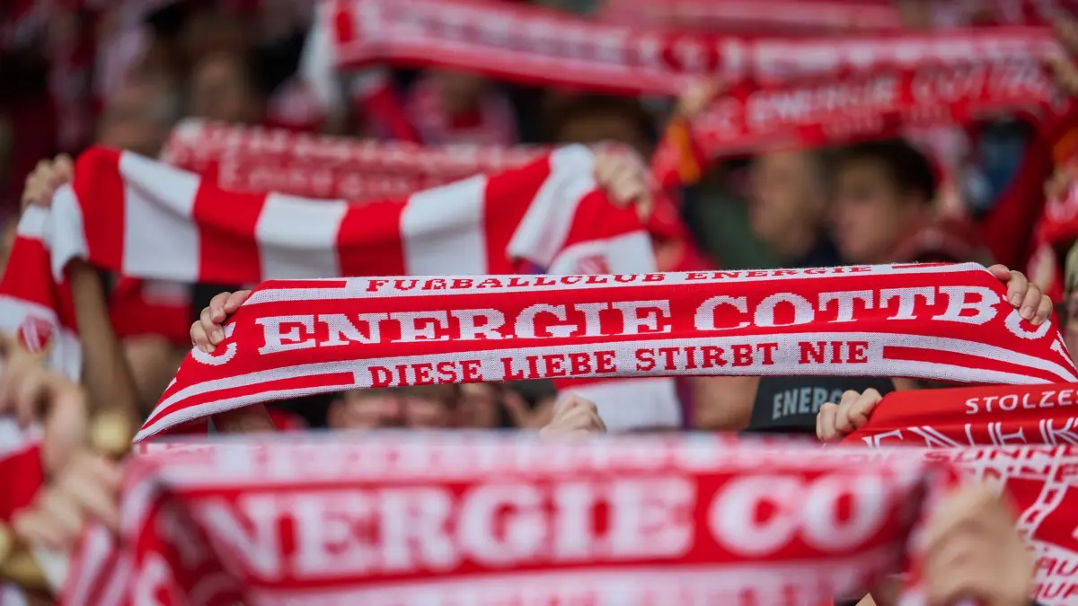 FC Energie Cottbus - FC St. Pauli: Fußball, Männer: 2. Bundesliga, FC Energie Cottbus - FC St. Pauli, 6. Spieltag, LEAG Energie Stadion, Fans von Energie Cottbus halten ihre Schals hoch. (zu dpa: «Cottbuser Hass-Plakate gegen St. Pauli-Fans»)