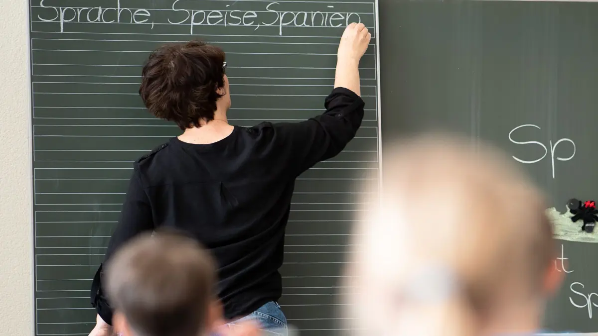 Schule ohne Präsenzpflicht: ARCHIV - 13.05.2019, Baden-Württemberg, Remshalden: Eine Lehrerin schreibt in einer Grundschule Worte an eine Tafel. (zu dpa: «Forderungskatalog für bessere Schulen in Schleswig-Holstein») Foto: Sebastian Gollnow/dpa +++ dpa-Bildfunk +++