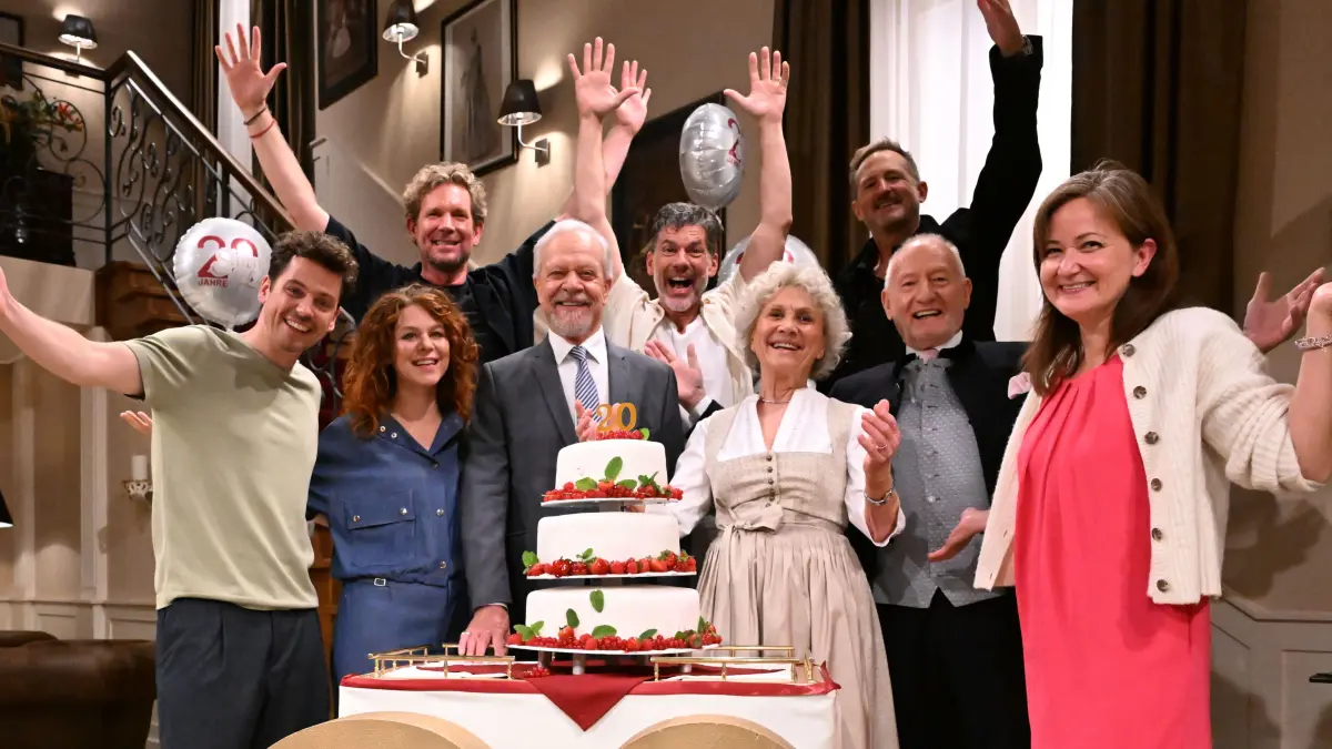 Die Schauspieler Anthony Paul (l-r unten) Johanna Graen, Dirk Galuba, Gregory B. Waldis, Antje Hagen, Sepp Schauer und Lara Okamoto, Redaktion BR, sowie der Produzent Peter Proske-Clayton (l-r, oben) und der Geschäftsführer Content bei Bavaria Fiction, Marcus Ammon stehen im Studio mit einer Geburtstagstorte beim Pressetag zu 20 Jahren "Sturm der Liebe"