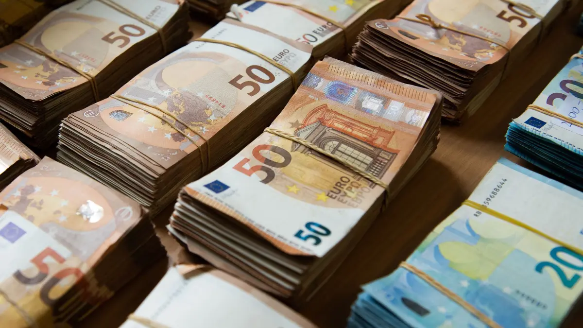 Beschlagnahmte Euro-Banknoten: Euro-Banknoten liegen während einer Pressekonferenz im Bundeskriminalamt gebündelt auf einem Tisch. Die Euro-Banknoten wurden bei Hausdurchsuchungen beschlagnahmt. Ermittler haben zuvor einen kriminellen Online-Marktplatz für Drogen und andere illegale Waren ausgehoben. (zu dpa: «EU-weite Abschöpfung von ergaunertem Vermögen soll leichter werden»)