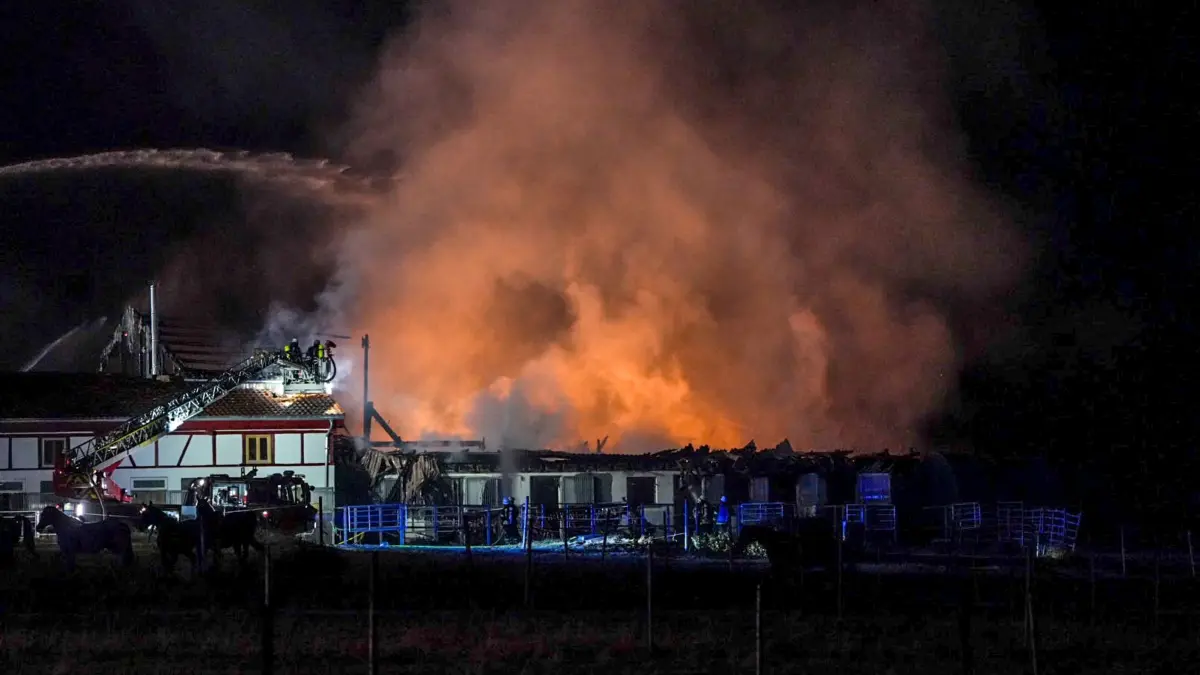 Großbrand auf landwirtschaftlichen Anlage in Tübingen: 26.09.2026, Baden-Württemberg, Tübingen: Einsatzkräfte der Feurwehr löschen einen Brand auf einer landwirtschaftlichen Anlage. Ein Großbrand auf einer landwirtschaftlichen Anlage in Tübingen sorgt aktuell für einen Feuerwehreinsatz. Wie ein Sprecher der Polizei sagte, steht unter anderem eine Reitanlage in Flammen. Foto: Enrique Kaczor/dpa +++ dpa-Bildfunk +++