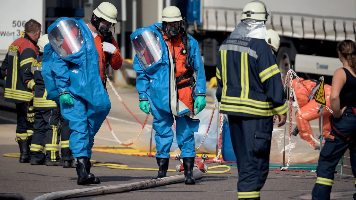 Chemikalienaustritt: Helfer in Schutzanzügen und mit Gasmasken sind im Einsatz, nachdem bei einem Unternehmen Chemikalien ausgetreten waren. (zu dpa: «Chemieunfall bei Firma – Arbeiter schwer verletzt»)