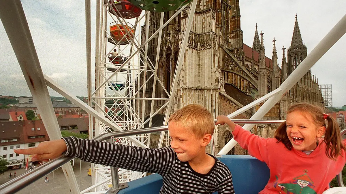 Ulm, Münsterplatz, Riesenrad, Eröffnung: Zwei Kinder sitzen in einer Gondel des Riesenrads und schauen nach unten, im Hintergrund das Ulmer Münster. Aus Anlaß des Schwörbrief-Jubiläums hat die Ulmer City Werbegemeinschaft ein Riesenrad auf den Münsterplatz stellen lassen. Das sei "die Attraktion neben dem höchsten Kirchturm der Welt" sagte Werbegemeinschafts-Vorsitzender Werner Vollmer gestern Mittag bei der Eröffnung.