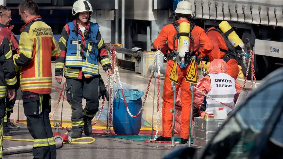 Helfer in Schutzanzügen und mit Atemschutzmasken sind in Dinkelsbühl im Einsatz, nachdem bei einem Unternehmen Chemikalien ausgetreten sind.