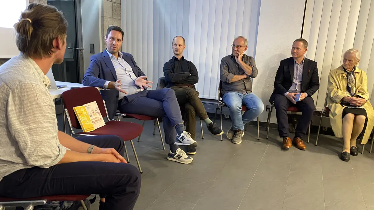 Über Demokratie ins Gespräch kommen, andere Meinungen anhören und aushalten, Menschen begegnen: Nach dem Impulsreferat von Rainald Manthe (zweiter von links) tauschen sich die Besucherinnen und Besucher im Arkadenforum rege aus.