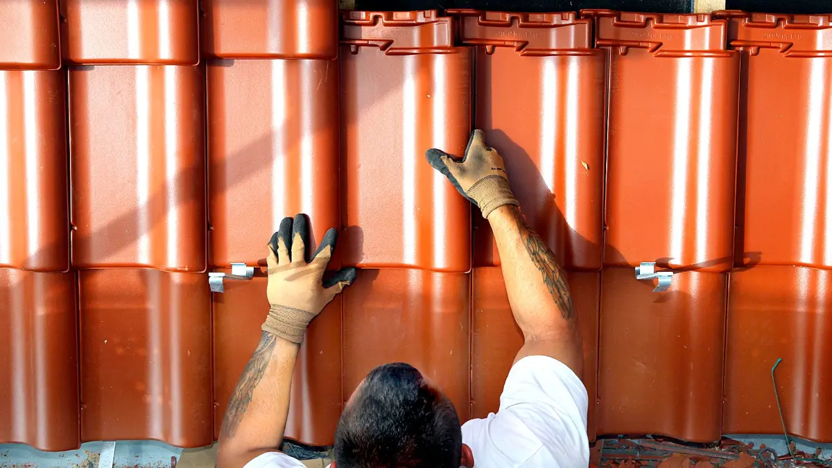 Ein Dachdecker beim Legen von Pfannen.