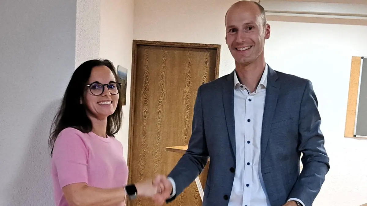 Wahlleiterin Sina Rios Palacio (links) gratuliert Christian Weber (rechts) zur Wiederwahl als Bürgermeister