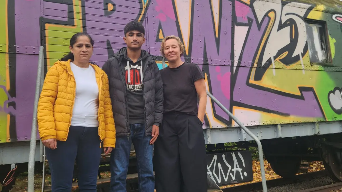 Cennet, Ali und Alis ehemalige Lehrerin Susanne Sonnek vor dem Bauwagen der Französischen Schule.