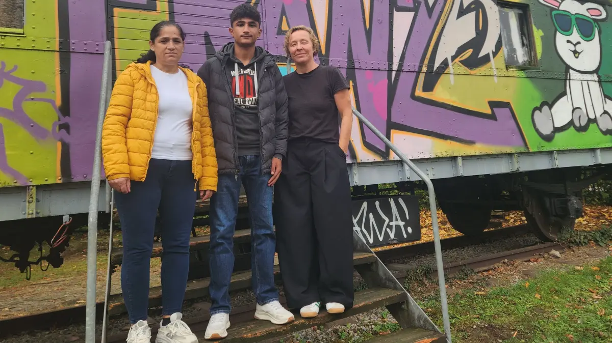 Cennet, Ali und Alis ehemalige Lehrerin Susanne Sonnek vor dem Bauwagen der Französischen Schule.