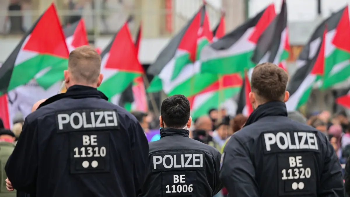 Propalästinensische Demonstration: Palästinensische Fahnen werden während einer Demonstration hinter Polizeibeamten geschwungen. (Archiv) (zu dpa: «Antiisraelische Demonstration am 7. Oktober? - Polizei berät»)