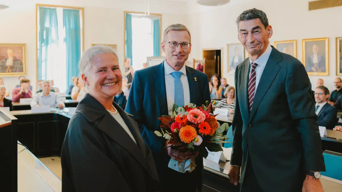 Rektorin Karla Pollmann und Bernhard Sibold, Vorsitzender des Universitätsrats (rechts), gratulieren Kanzler Andreas Rothfuß zur Wiederwahl.