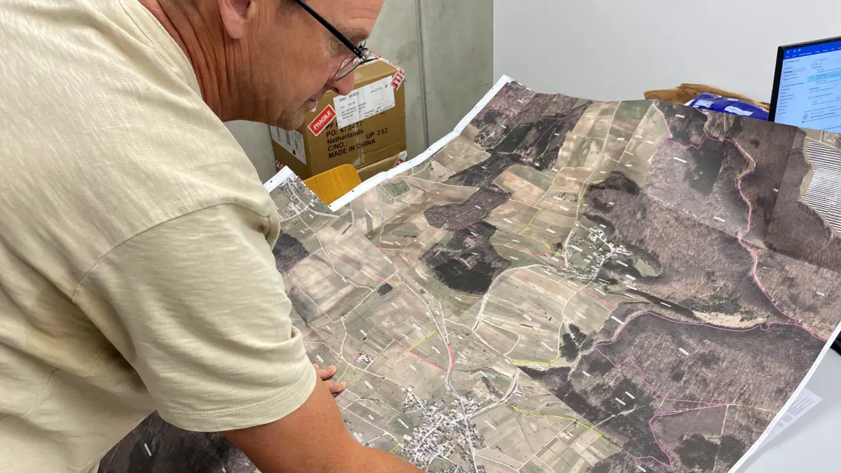 Altsteußlingens Ortsvorsteher Josef Huber sucht nach einem alten Brunnen im Wald, auch mit einer Flurkarte für das Suchgebiet.