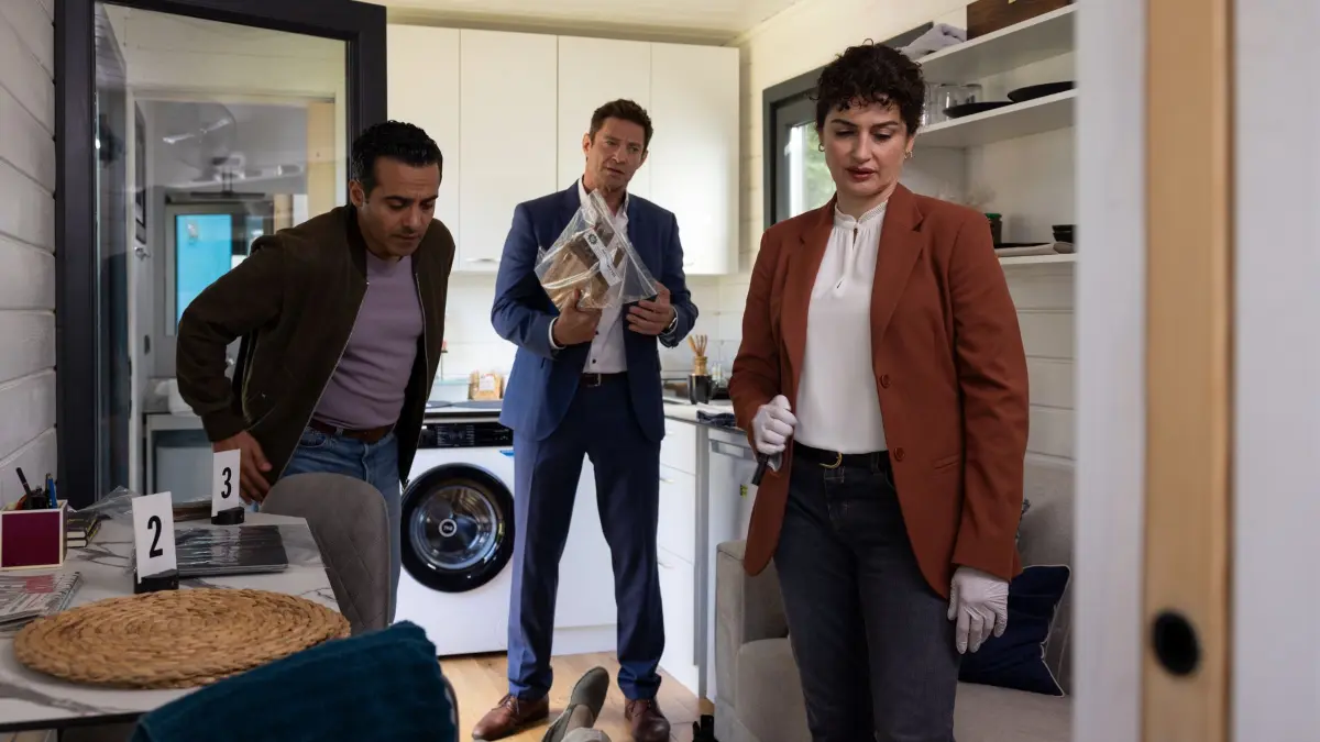 Im Tiny House gibt Rechtsmedizinerin Dr. Dimos (Anastasia Papadopoulou, r.) den Kommissare Hansen (Igor Jefti?, M.) und Kaya (Baran Hêvî, l.) Informationen zum möglichen Tathergang und zum Tod des Opfers (Komparse).