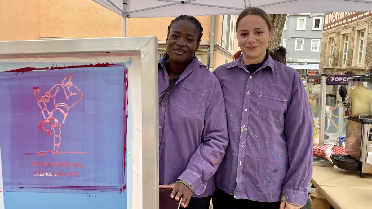 Leila und Magda vom Mädchencafé Reutlingen bedrucken mit den Besucherinnen Taschen und Jutebeutel mit besonderen Botschaften.