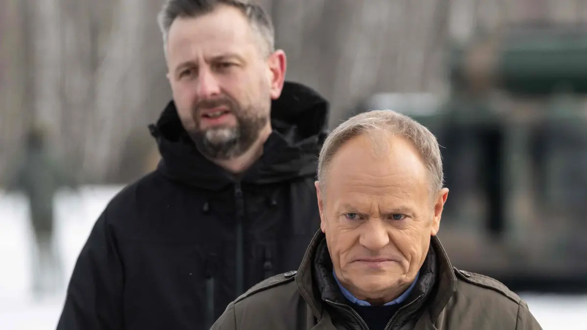 FILES-POLAND-POLITICS-DIPLOMACY-PARLIAMENT: (FILES) Poland's Deputy Prime Minister and Minister of Defence Wladyslaw Kosiniak-Kamysz (L) and Prime Minister Donald Tusk (R) walk after watching an open test of unmanned weapon systems conducted by the Polish Armaments Group (Polska Grupa Zbrojeniowa) at the Military Institute of Armament Technology training ground in Zielonka, a Warsaw suburb, on February 19, 2026. Poland's interior ministry said on October 11, 2026 police suspected that the country's Prime Minister Donald Tusk and Defence Minister Wladyslaw Kosiniak-Kamysz had been targeted by assassination attempts. The ministry ordered authorities to take action "in connection with the information received by (police) concerning a possible assassination attempt on the prime minister ... as well as the deputy prime minister", who is also defence minister, interior spokeswoman Karolina Galecka wrote on X. (Photo by Wojtek RADWANSKI / AFP)