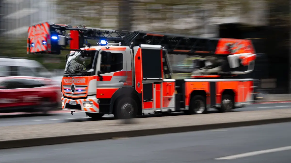 Feuerwehreinsatz: ARCHIV - 30.10.2024, Hessen, Frankfurt/Main: Die Feuerwehr ist mit einem Einsatzfahrzeug mit eingeschaltetem Blaulicht und Drehleiter im Einsatz. (zu dpa: «Acht Bewohner aus brennendem Haus gerettet») Foto: Boris Roessler/dpa +++ dpa-Bildfunk +++