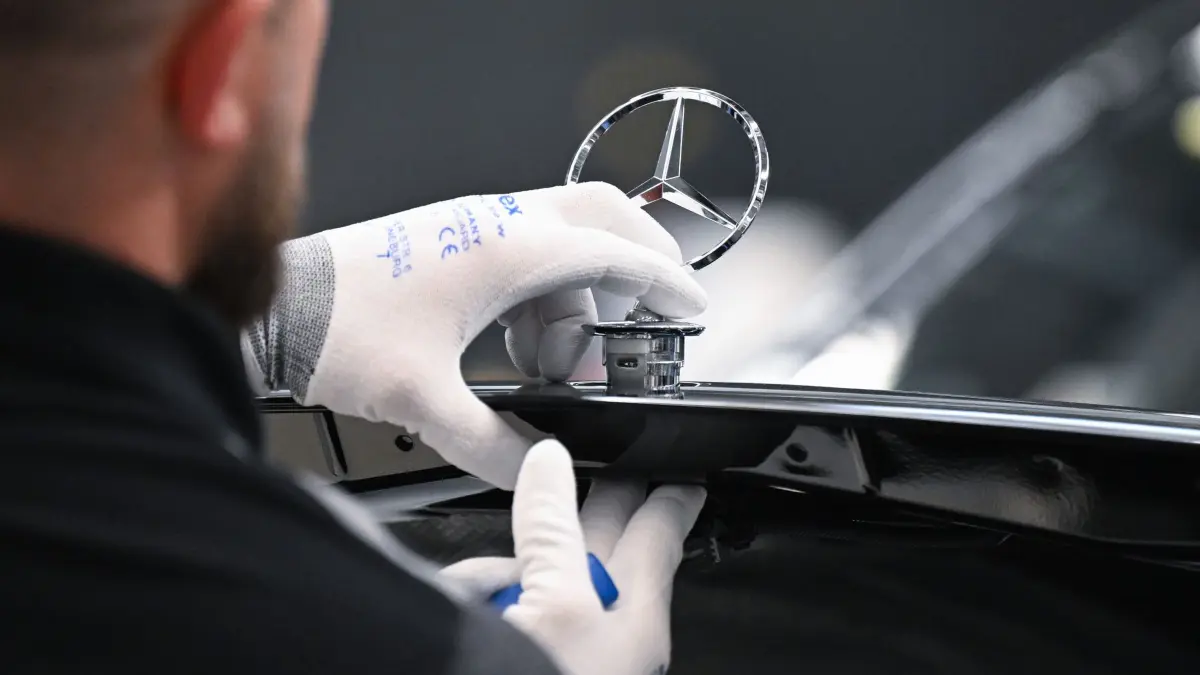 Mercedes-Benz: Ein Mercedes-Benz Arbeiter montiert im Mercedes-Benz Werk Sindelfingen in der Factory 56 einen Mercedes Stern auf ein Fahrzeug der S-Klasse. (zu dpa: «Es wird ein schwaches Jahr für die deutschen Autobauer»)