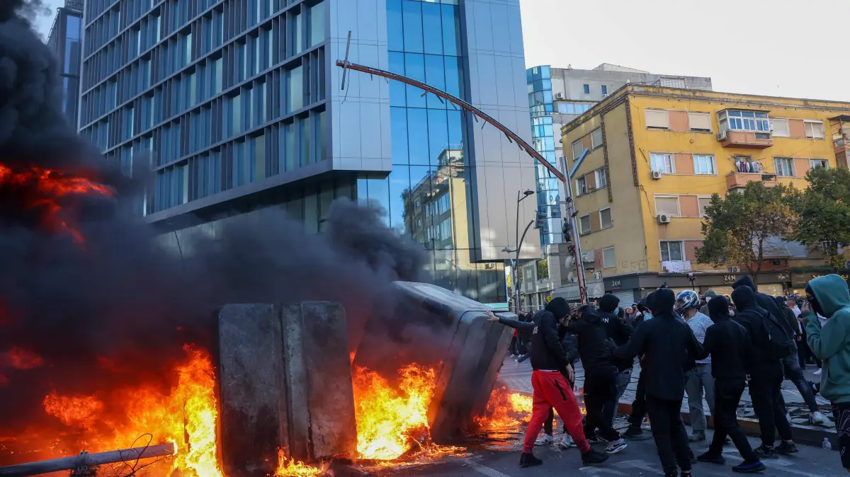 Dozens probed over violence at Albania student protest: Protesters set garbage bins on fire during clashes with police in central Tirana on October 14, 2026, as violence erupted for a second consecutive day during demonstrations demanding the resignation of Albanian Prime Minister Edi Rama and better education. The renewed clashes followed violence the previous day, when protesters threw stones, smashed windows at the Education Ministry, tore down a fence and set rubbish bins on fire. (Photo by Adnan Beci / AFP)