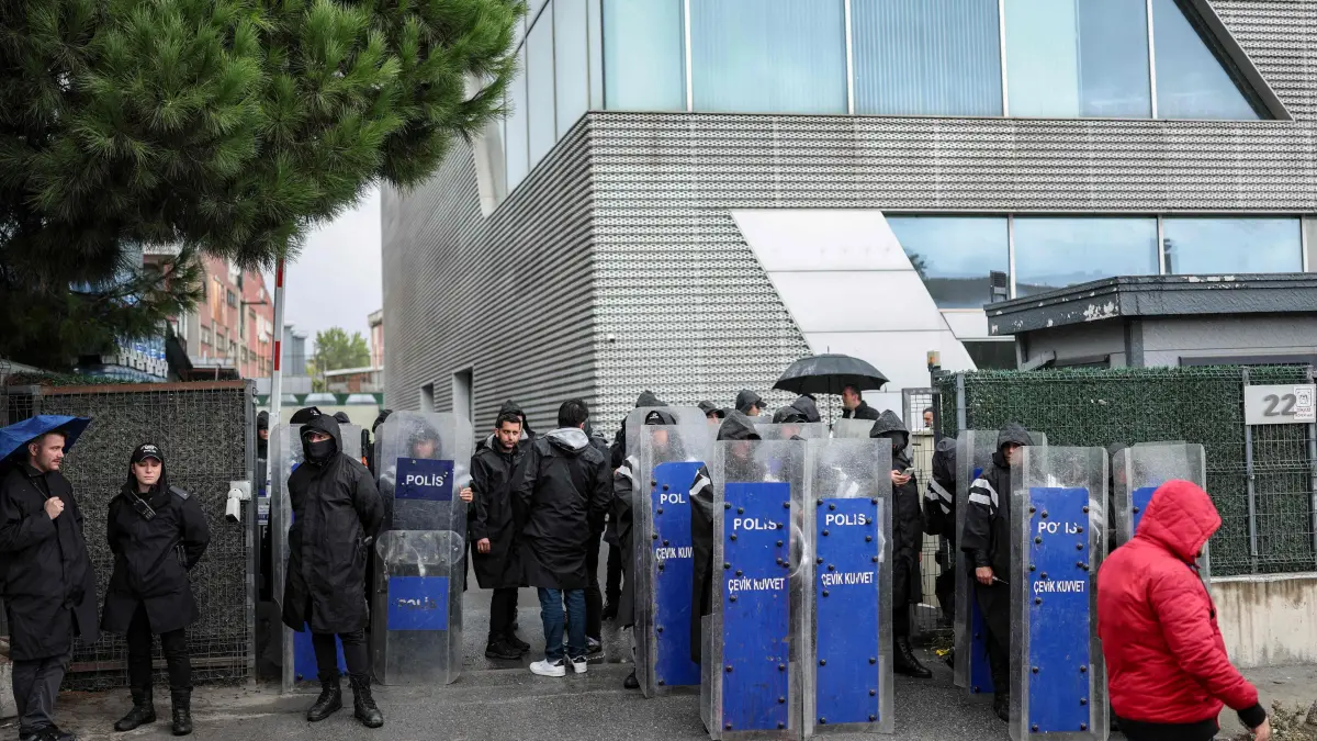 TURKEY-POLITICS-MEDIA-RIGHTS: Turkish anti-riot police officers stand at the bottom of the building during a police raid at the headquarters of pro-opposition Halk TV in Istanbul, on October 14, 2026. The head of Turkey's pro-opposition Halk TV lashed out after police raided the channel's headquarters, halting live broadcasts and arresting 11 in a move against the country's most watched news channel. (Photo by BERK OZKAN / AFP)