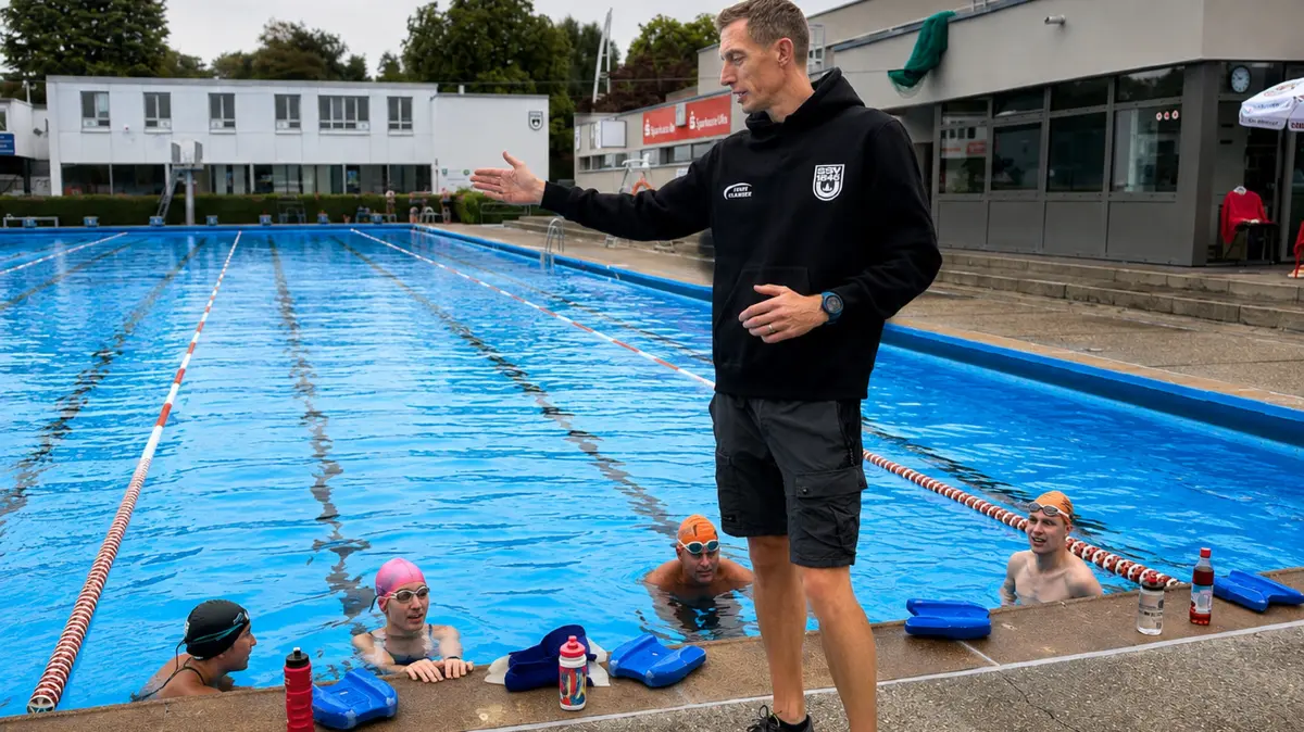 dere neue Trainer Andy Bullock am Beckenrand des SSV-Schwimmbads.