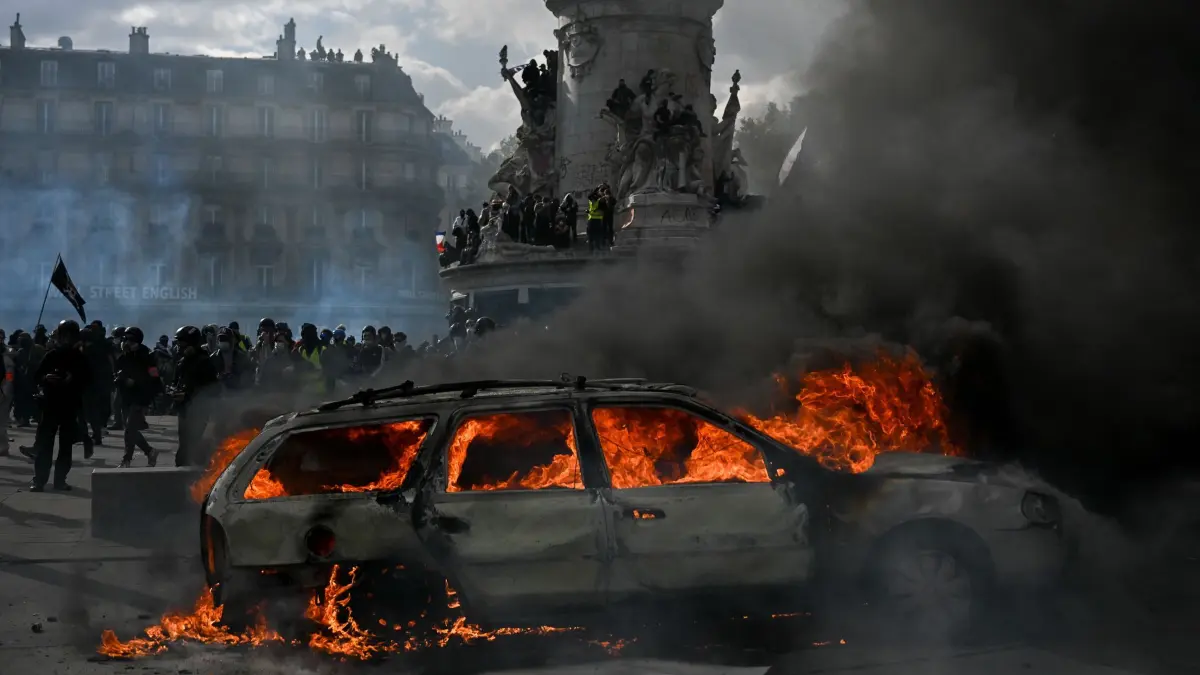Protesttag in Frankreich: Auf dem Place de la République brennt ein Auto während es zu Zusammenstößen zwischen Demonstranten und Polizeikräften kommt. (zu dpa: «Frankreichs Protesttag endet in Gewalt und Plünderungen»)