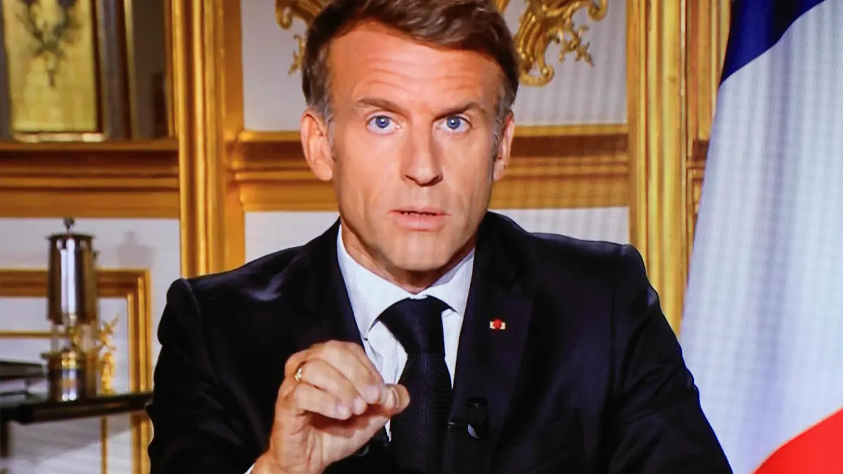 FRANCE-POLITICS-GOVERNMENT-SOCIAL-DEMO: This photograph shows a television monitor broadcasting France's President Emmanuel Macron giving a speech from the Elysee Presidential Palace the day after riots and looting on the sidelines of nationwide protests against the "high cost of living", in Paris on October 18, 2026. France's Interior Minister said 1,800 people were arrested in protests across the country on October 17, and 600 police officers, gendarmes and firefighters were hurt during clashes. On October 17, 550,000 people took part in demonstrations against the high cost of living, including 110,000 in Paris, according to official figures. In many cities across France, the day of protests descended into chaos, marked by clashes and looting. (Photo by Ludovic MARIN / AFP)