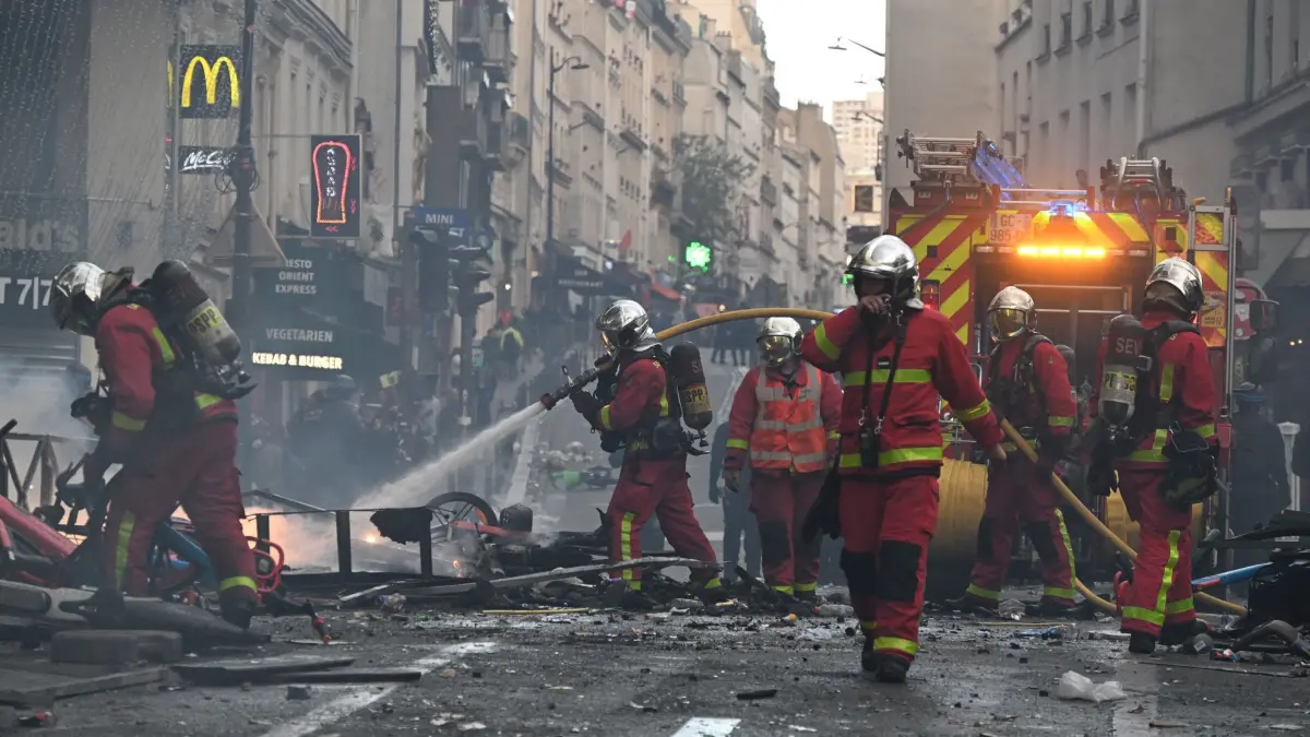 Protesttag in Frankreich: Feuerwehrleute löschen einen Brand während einer Demonstration gegen steigende Lebenshaltungskosten, bei der sich die Teilnehmer den Forderungen der Studenten anschlossen haben. (zu dpa: «Frankreichs Protesttag endet in Gewalt und Plünderungen»)