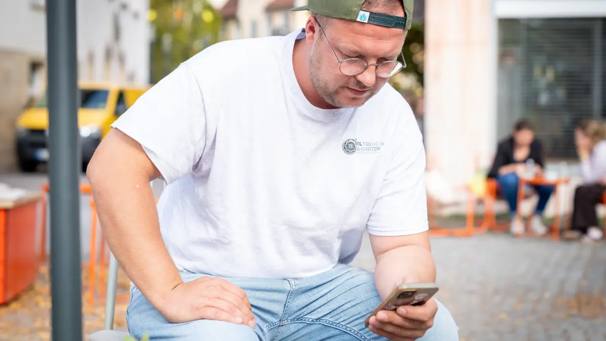 Am Smartphone demonstriert Timo Ludersdorfer wie WorkSync funktioniert. Rottenburg Seebronn KI
