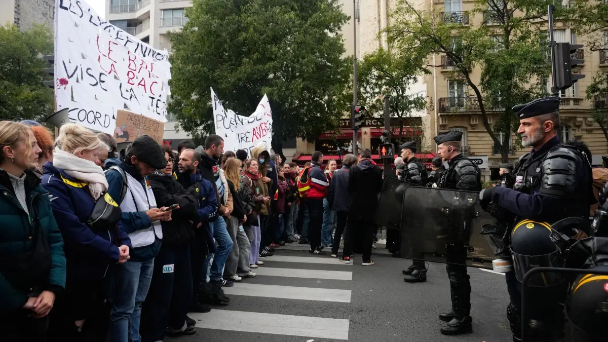 Proteste in Frankreich: 22.10.2026, Frankreich, Paris: Demonstranten stehen Polizisten gegenüber, während eines Protests gegen die schlechten Bildungsbedingungen an Schulen. Foto: Teresa Suarez/AP/dpa +++ dpa-Bildfunk +++