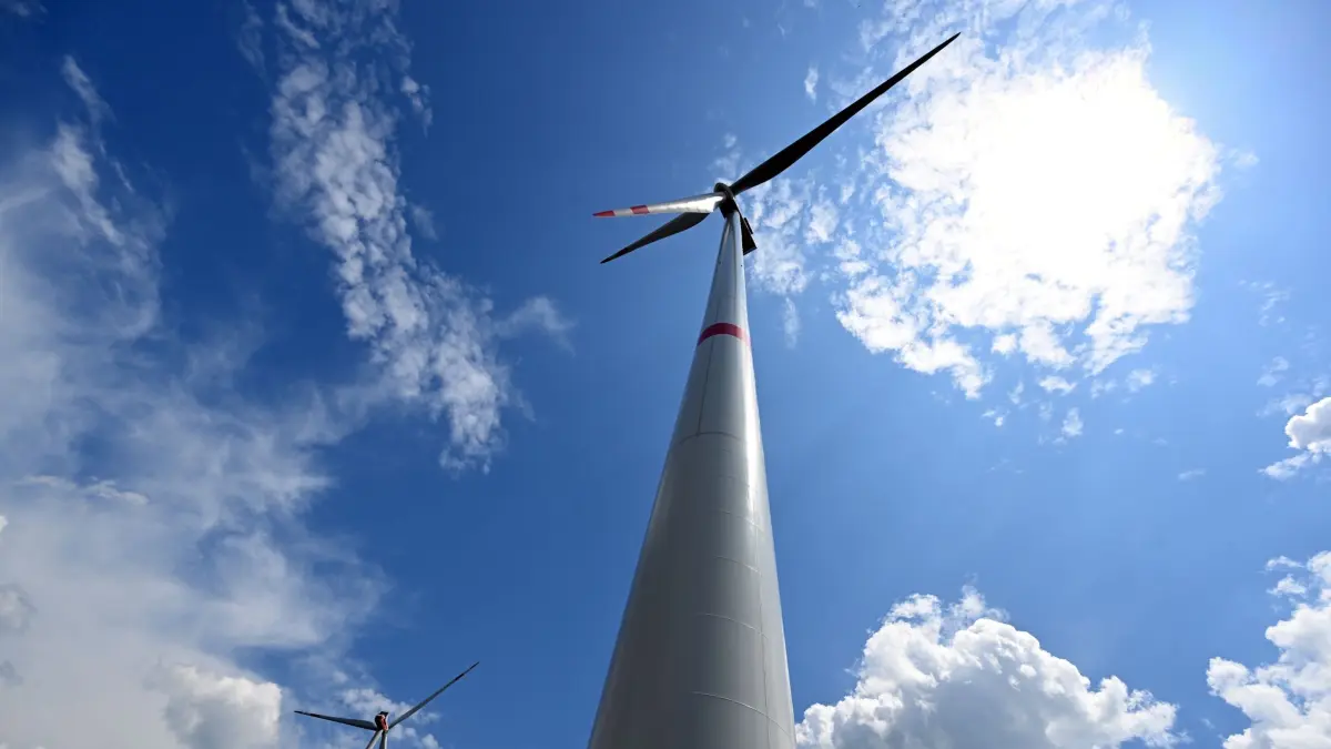 Windräder in NRW: ARCHIV - 06.06.2023, Nordrhein-Westfalen, Bad Berleburg: Wolken ziehen über Windräder zur Stromerzeugung. NRW verfügt über immer mehr Windkraft, die 10 Gigawatt-Marke wurde geknackt. (zu dpa: «NRW knackt die 10-Gigawatt-Marke bei Windkraft») Foto: Federico Gambarini/dpa +++ dpa-Bildfunk +++