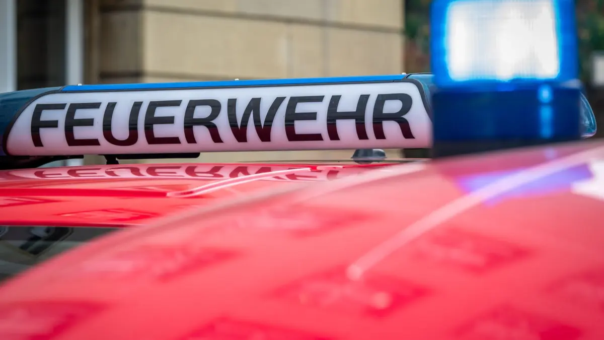 Leiche bei Brand in Berliner Kellerwohnung gefunden : Der Schriftzug „Feuerwehr“ ist neben einem blau leuchtenden Sondersignal auf dem Dach eines Fahrzeuges der Feuerwehr zu sehen. (zu dpa: «Leiche bei Brand in Berliner Kellerwohnung gefunden»)