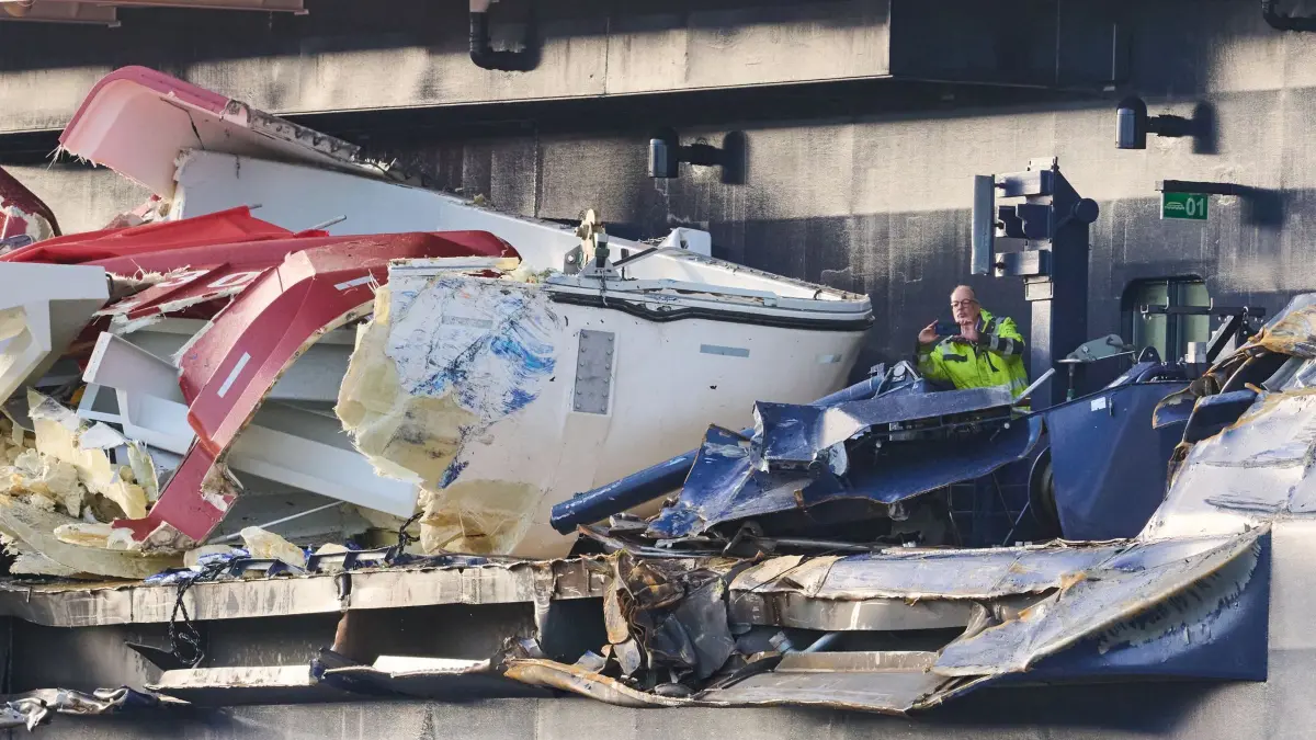 Kreuzfahrtschiff stößt mit Containerschiffen zusammen: 26.10.2026, Bremen, Bremerhaven: Zwei Männer begutachten den Schaden an der «Mein Schiff 3». Das Kreuzfahrtschiff war am Vortag bei stürmischem Wetter mit zwei Containerschiffen kollidiert. Foto: Sina Schuldt/dpa +++ dpa-Bildfunk +++