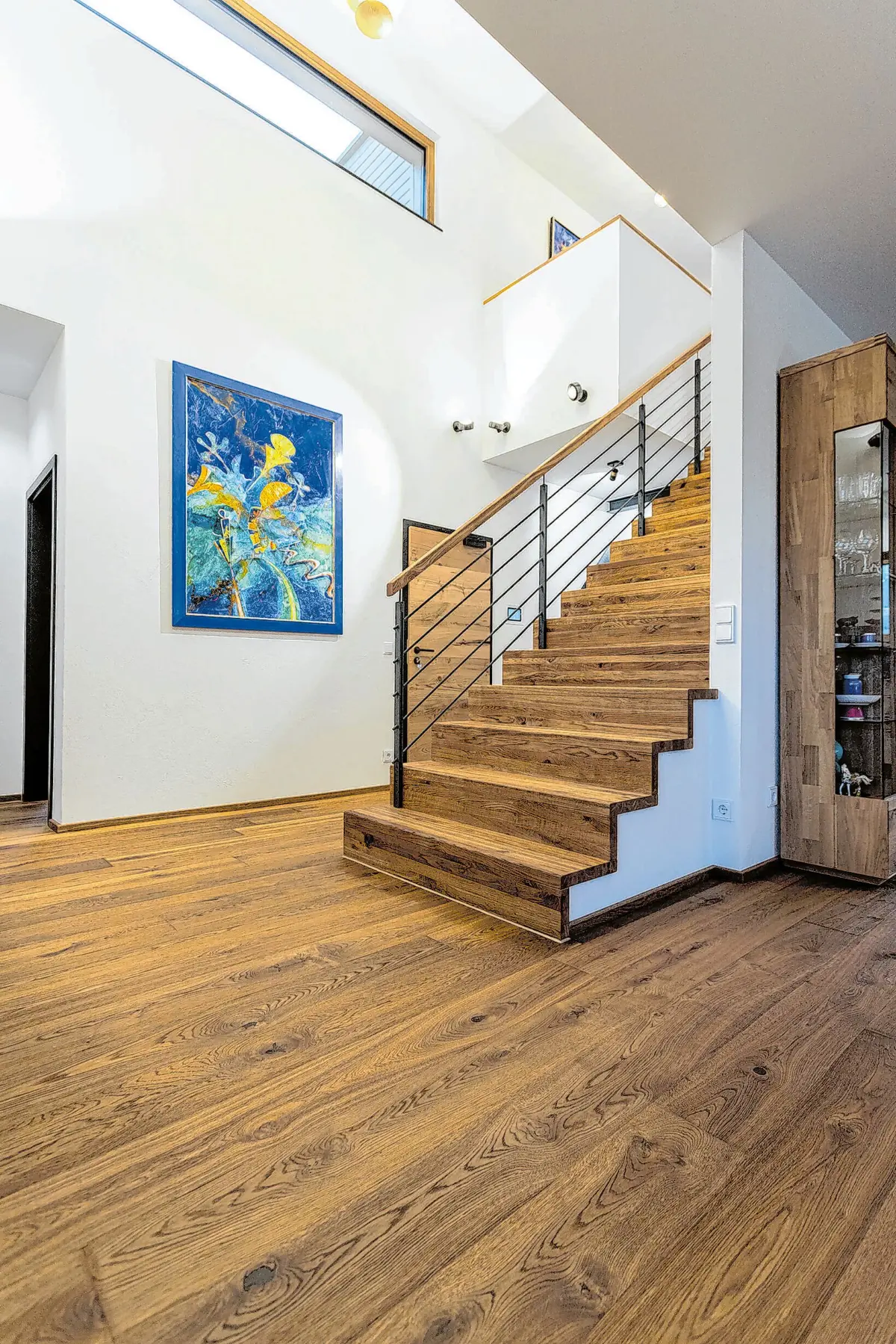 Stilvolles Ambiente: Dank des einheitlichen Looks gehen Bodenbelag und Treppe scheinbar nahtlos ineinander über. Foto: HLC/Bembé Parkett