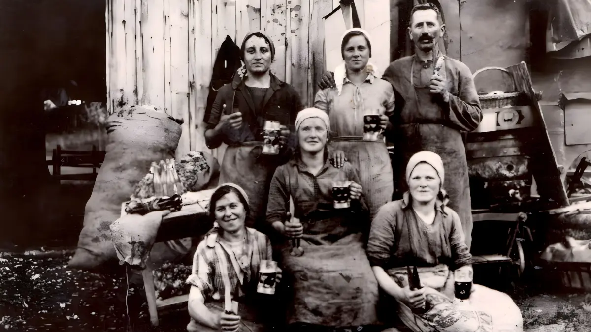 1250 Jahre Meidelstetten. Singende Schafschererinnen. Die singenden Schafschererinnen aus Meidelstetten erleichterten sich die anstrengende Arbeit mit Gesang und, wie auf der historischen Aufnahme zu sehen ist, auch mit Bier. Von links: Julie Baisch, Rosa Kißling und Frida Baisch, dahinter Luise Rauscher sowie ein Schäfer mit seiner Frau.
