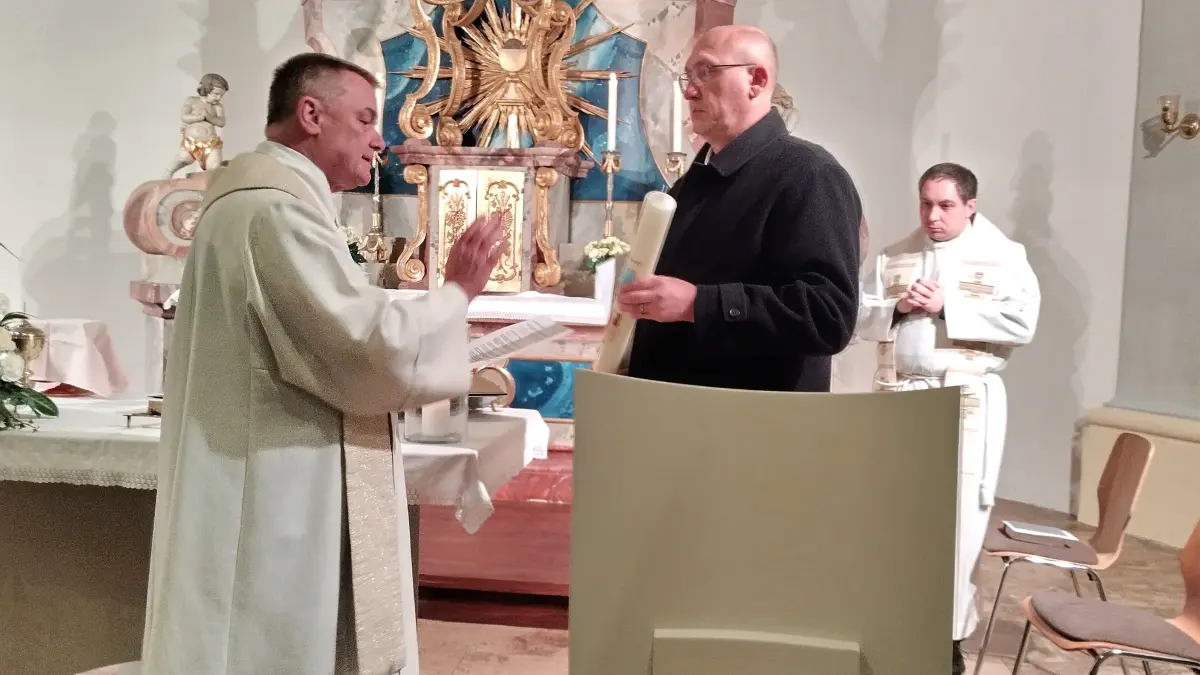 Pfarrer Thomas Fürst segnet die vom neuen Kerzenmeister Rainald Riede gehaltene Kerze. Im Hintergrund: Der neue Haigerlocher Pfarrer Vikar Sandro Pröbstle.