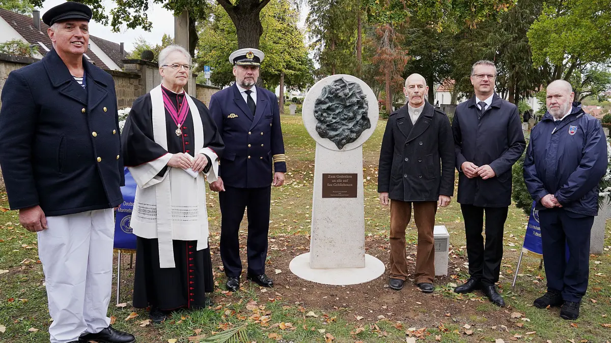 Das Denkmal „Für alle auf See Gebliebenen“ auf dem Klausenfriedhof in Rottenburg wurde am 11. Oktober 2026. enthüllt und eingeweiht. Anlass war der Abgeordnetentag des Deutschen Marinebunds in der Stadt. Von rechts Egon Ruf (Vorsitzender der Marinekameradschaft Rottenburg), Oberbürgermeister Stephan Neher, Bildhauer Ralf Ehmann, Fregattenkapitän Marco Thiele, Generalvikar Clemens Stroppel und Armin Neu (Marinekameradschaft).