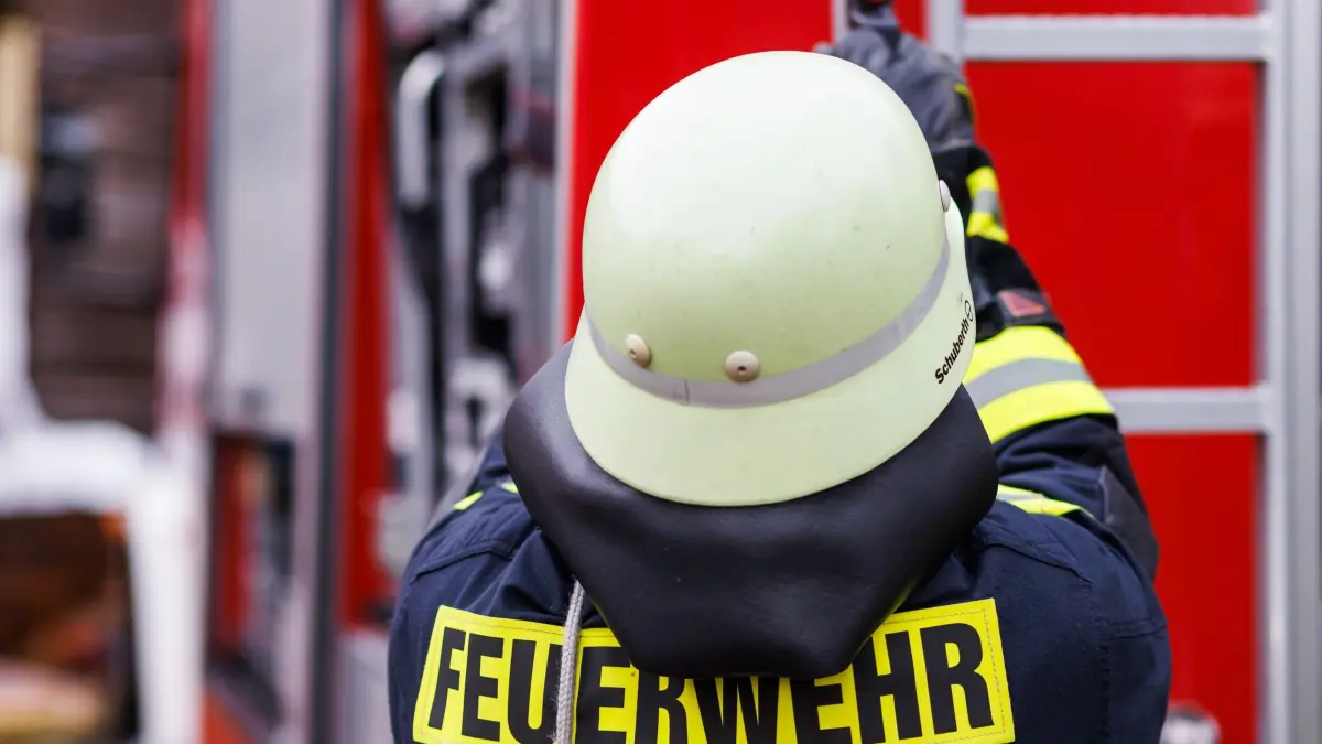 Feuerwehr - Symbolbild: Ein Feuerwehrmann holt während einer Einsatzübung einer Freiwilligen Feuerwehr eine Leiter vom Dach eines Einsatzfahrzeugs. (zu dpa: «Technischer Defekt löste Brand in Einkaufszentrum aus»)